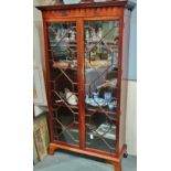 A Georgian style glazed tall bookcase with astragal doors fitted five adjustable shelves below a