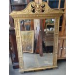 A 19th century Neoclassical style wall mirror with broken arch pediment and bevelled glass, height