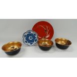 A set of three Japanese black and gilt painted lacquer bowls, together with a black lacquer dish and