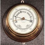 A brass and oak cased barometer by John Barker and Company Limited of Kensington.
