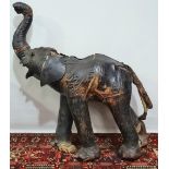 An early 20th century Liberty style leather baby elephant figure with glass style eyes, height 125cm