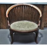 An Edwardian mahogany bow back armchair with cabriole legs and upholstered seat.