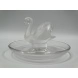 A Lalique glass pin dish with central swan, inscribed 'Lalique France' to the base, diameter 9cm.