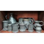 A collection of pewter measures and mugs.