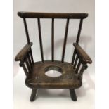 An early English or Welsh child's elm commode chair with stickback slab seat and turned legs, with