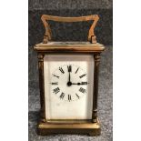 A brass carriage timepiece with corniche case, height including handle 14.5cm.
