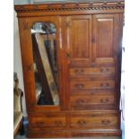 A late 19th century oak wardrobe with Gothic influenced decoration to the pediment fitted five