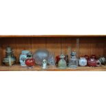 A collection of glass oil lamps and shades, including cranberry, together with two brass oil lamps.