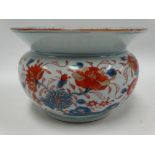 A Chinese Imari ovoid pot with flared rim, glazed blue and red and gilt painted with rocks issuing