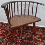 An 18th century bow back chair in elm and ash with thirteen spindle back, lacking one spindle,