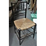 An Arts & Crafts style Sussex chair with ebonised frame and strung seat.