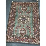 A 20th century middle eastern wool hand knotted rug decorated with three medallions amongst multiple