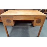 A Chinese blond hardwood desk fitted three drawers and carved roundels to each side and raised on