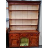 An early 19th century pine Cornish style dresser with open rack fitted three drawers and central dog