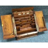 A Victorian walnut and brass inlaid desktop stationary cabinet, opening to reveal numerous