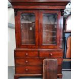 A 19th century mahogany and glazed bookcase with doors above a chest of five drawers on bracket