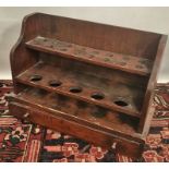 A stained pine pipe rack with frieze drawer, width 41cm.