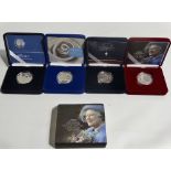 Two silver proof commemorative crowns and two silver commemorative £5 coins.