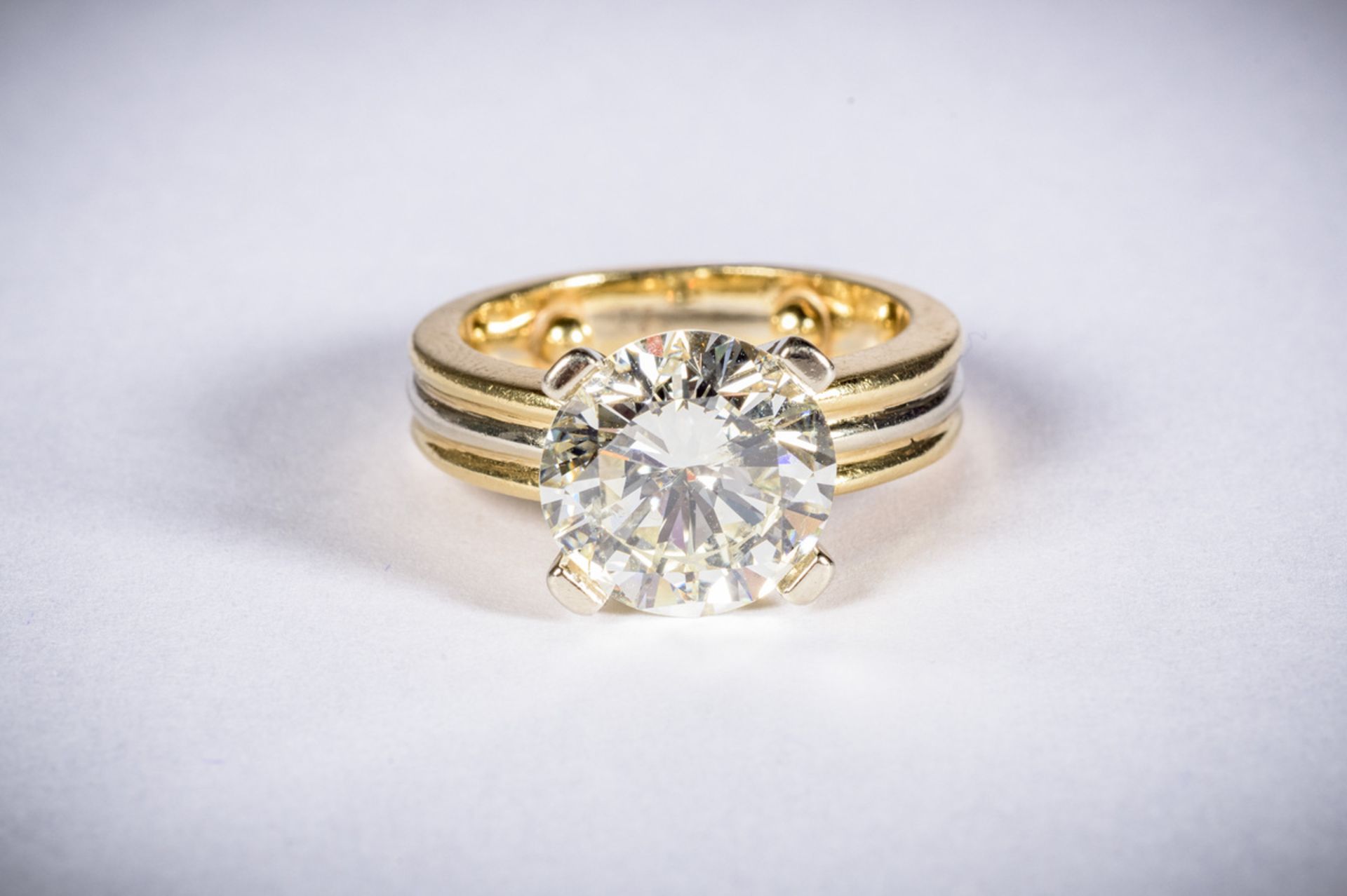 Ring with a solitaire brilliant 'new cut' and gold mount, approximately 4.50 kt (rare white -