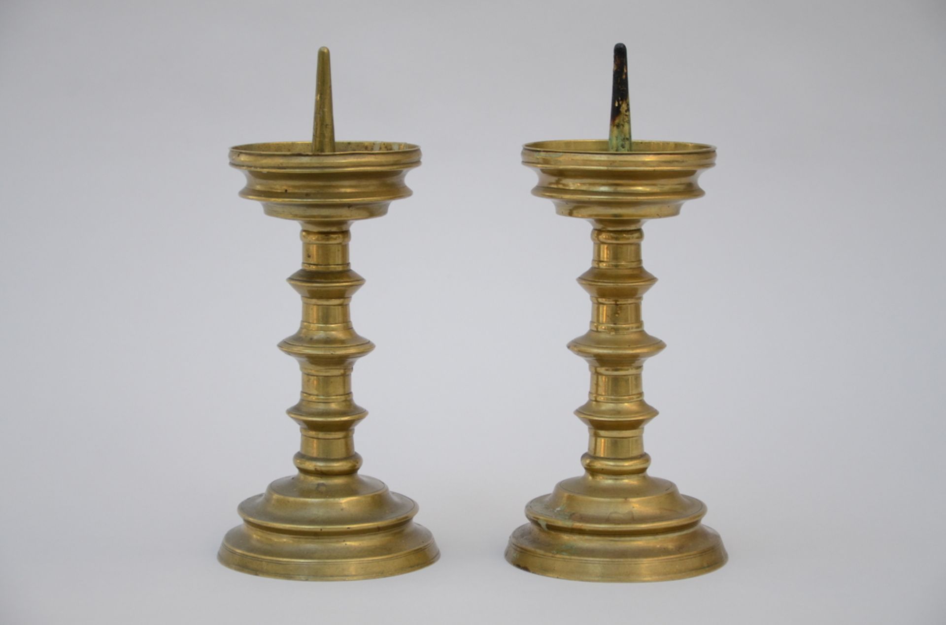 A pair of bronze candlesticks (29cm)+ a plate in polychromed Delft (dia35cm)