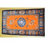 A wool Chinese carpet with orange ground (190x109cm)