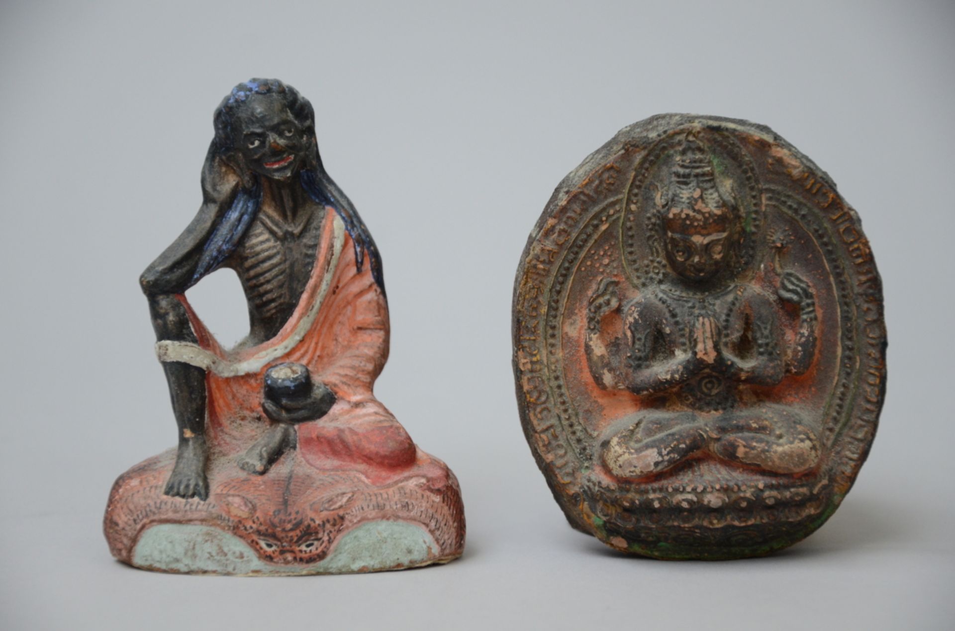 Lot: Tibetan clay sculpture 'Milarepa' (h9.5cm) + a tsatsa plaque (9x7.5cm)