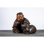 A Japanese okimono in wood 'boy with dog', signed (6x8x7cm) (*)