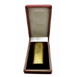 A Cartier gold plated lighter with the case. 7 x 2.5 cm.