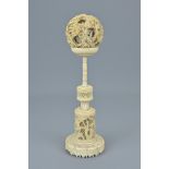 A CHINESE IVORY PUZZLE BALL ON AN IVORY STAND