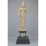 A CAMBODIAN KHMER CARVED STONE FIGURE OF FOUR-ARMED GODDESS ON PLINTH