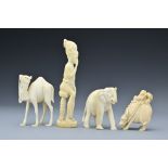 A group of ivory carvings to include a figure of a seated man, an elephant, a camel and figure on
