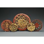 Five red gilt-lacquer carved circular panels in varying sizes. Largest diameter approx. 34 cm.