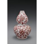 A Chinese 20th Century underglaze-red vase in the form of a double gourd, decorated with floral