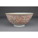 A Chinese 19th Century iron-red porcelain bowl decorated with scrolling peonies. The base with