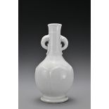 A Chinese 17/18th Century white-glazed porcelain bottle vase. The rounded body decorated with raised