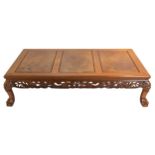 A Chinese hardwood low coffee table with three burr panels on top. Carved with dragons and clouds