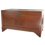 A Chinese carved camphorwood chest with sliding shelf inside, metal mounts and lock and key.