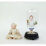 Porcelain doll and Christ under bell jar
