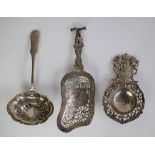 A collection of a silver sugar shaker, tea strainer and olive spoon, German & Holland