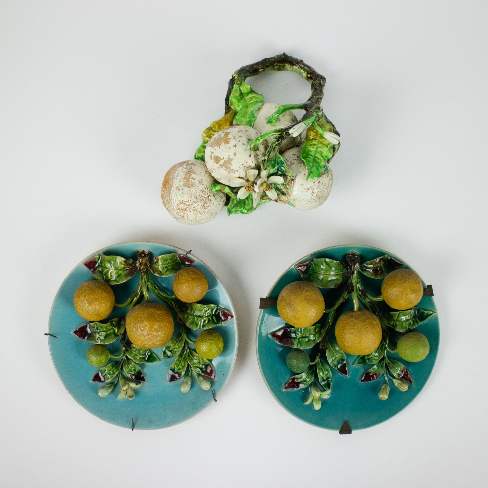 2 old faience plates barbotine with relief of oranges and a bunch of fruits