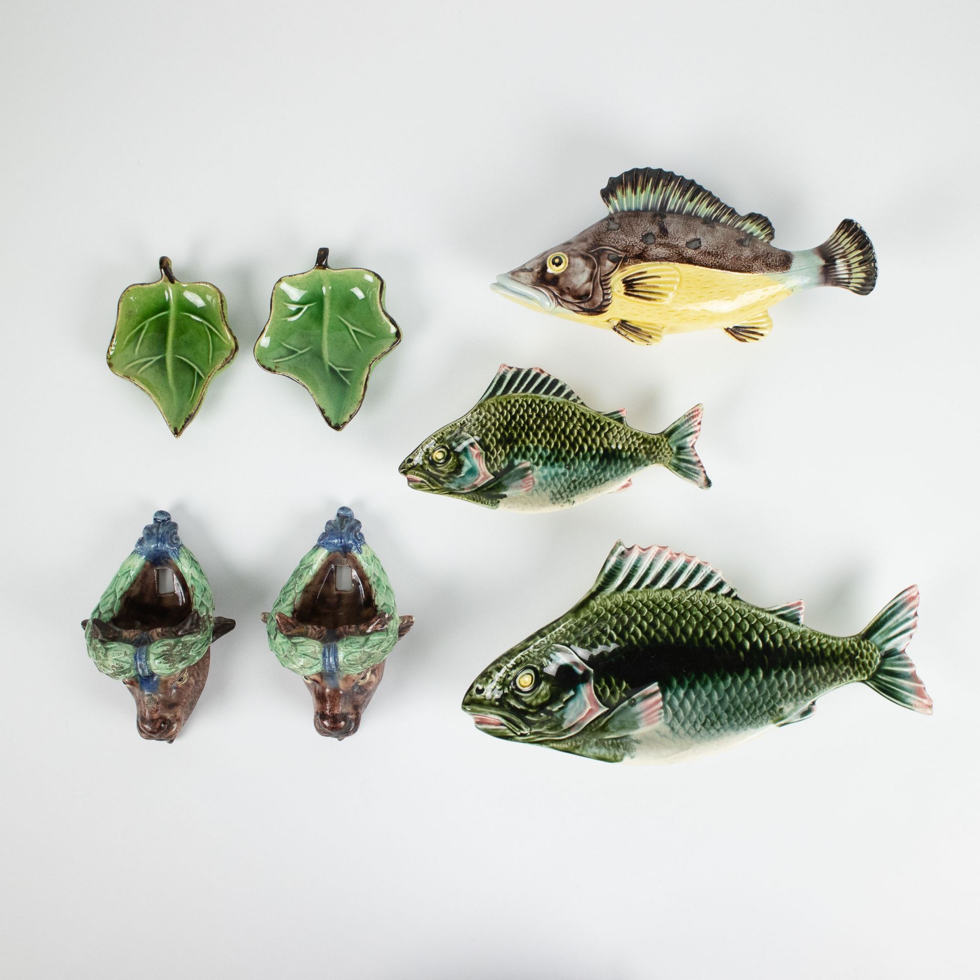 A collection of ornamental glazed pottery, bulls, fish leaves