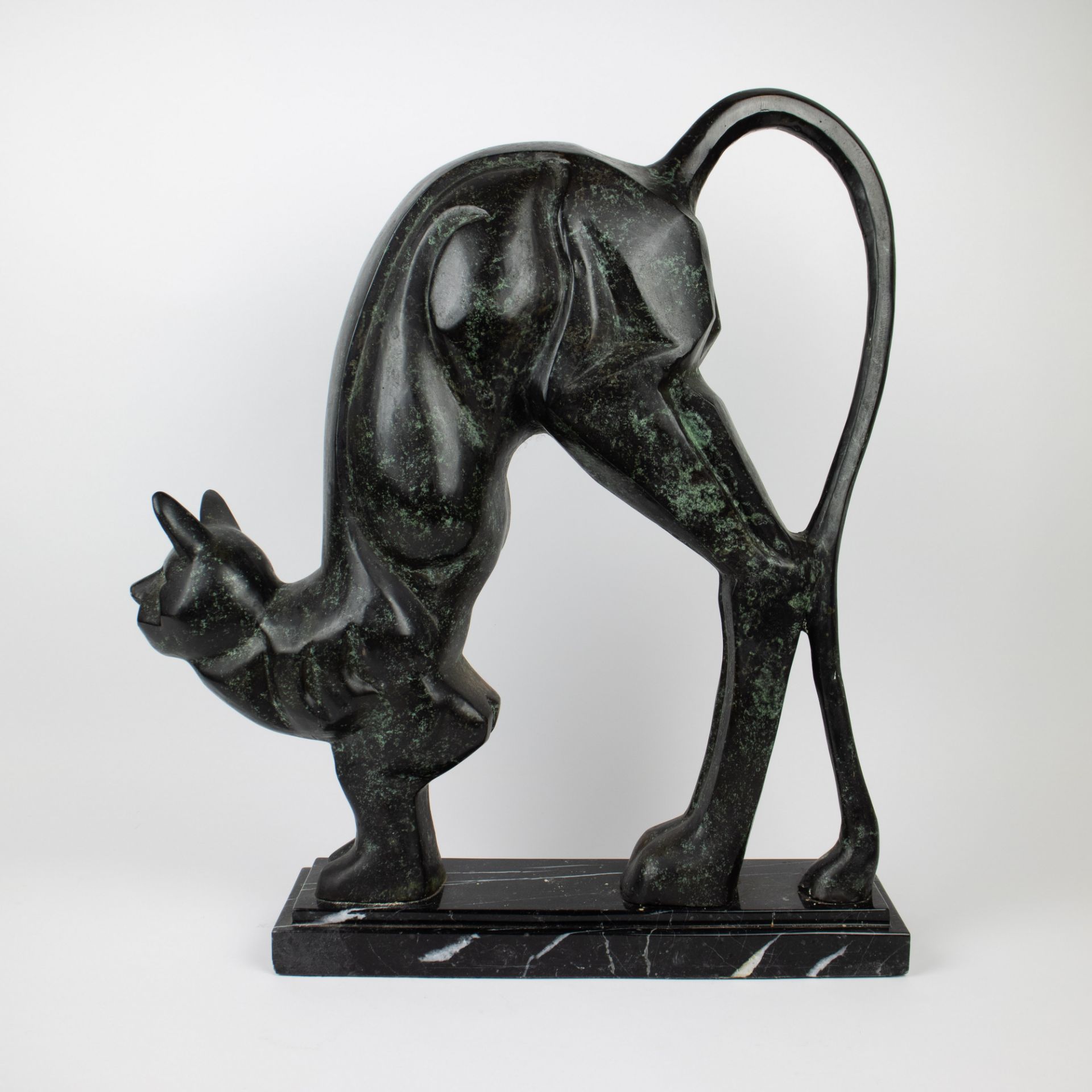 A bronze sculpture of a cat on marble base.