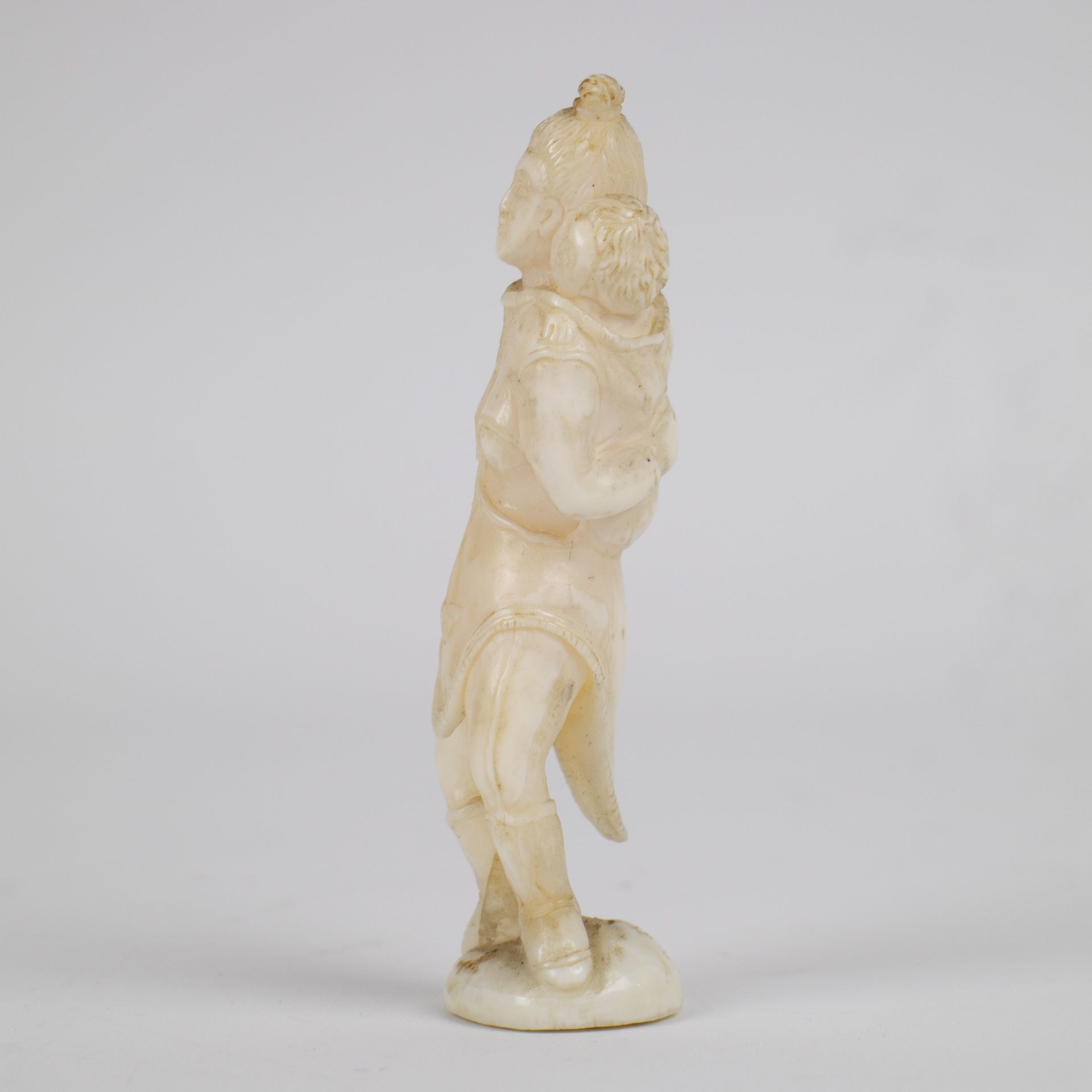 Marine ivory sculpture of a woman carrying a child on her back, Greenland, early 20th century. - Image 2 of 4