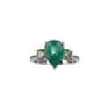 AN EMERALD AND DIAMOND THREE STONE RING