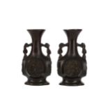 AN EARLY 20TH CENTURY PAIR OF JAPANESE BRONZE TWIN HANDLED VASES