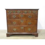 An 18th Century cross-banded walnut Chest of two short and three long drawers on bracket supports,