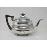 A George III silver boat shape Teapot with leafage engraved frieze and vacant cartouche on ball