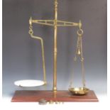 A set of W & T Avery brass Weighing Scales on mahogany base with ceramic and brass pans and a