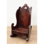 An antique child's Rocking Chair in fruitwood having shaped surmount and sides, solid seat and