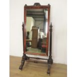 A 19th Century carved mahogany Robing Mirror, the cushion framed mirror between taper turned
